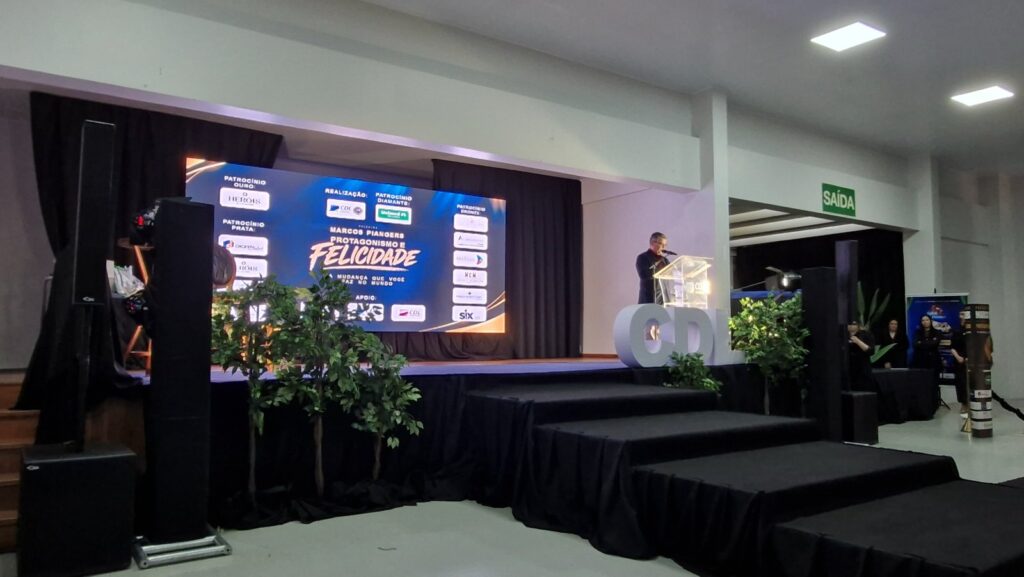 Palco da palestra de Marcos Piangers no Salão Paroquial Nossa Senhora de Fátima, em Vacaria